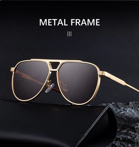 Detailed shot of gold metal pilot sunglasses with sleek black leather case on dark stones