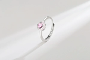 Detailed macro shot of an adjustable silver ring featuring a pink round stone and enamel