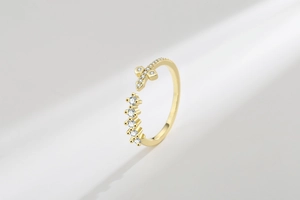 Detailed view of a gold-plated cross ring with micro-set cubic zirconia stones