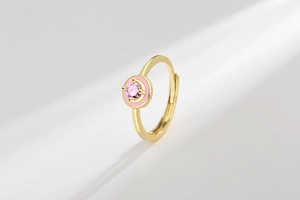 Detail of pink enamel round ring with sparkling gemstone inlay and adjustable gold band