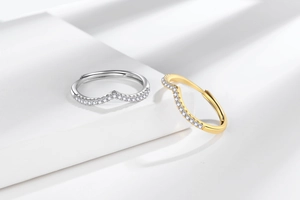 Close-up of V-shaped stacking rings with micro-pave crystals in silver and gold finish