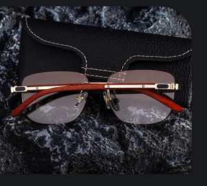 Close-up of rimless sunglasses with wood grain temples and metal screw detailing