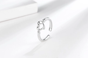Detail of silver heart-shaped open ring showing hollow design on white background