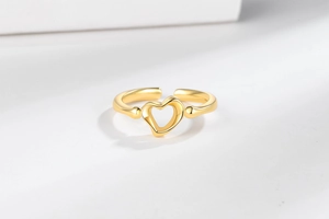 Close-up of a polished golden open ring featuring a minimalist hollow heart design