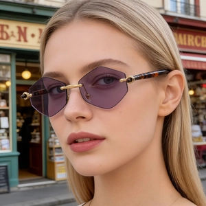 Macro shot of purple rimless geometric lenses with gold bridge and tortoiseshell temples