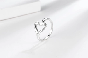 Close-up of polished silver heart-shaped open ring with sleek minimalist curves