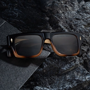 Men's square frame sunglasses with black gradient frames and brown lenses on rock background