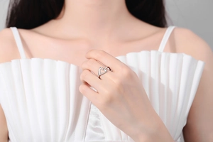Detailed close-up of a silver heart-shaped adjustable open ring worn by a model