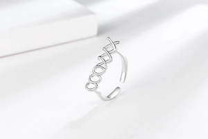 Detailed macro view of silver ring featuring cool hollowed letters and adjustable band