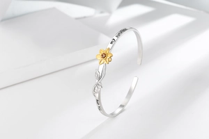 Detailed engraving of You are my sunshine on silver bangle with a golden sunflower