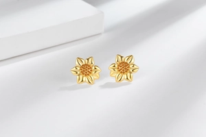 Detail of sunflower stud earrings featuring gold plating and orange cubic zirconia stones