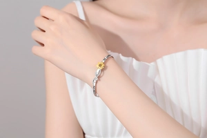 Detail of sunflower bracelet with You Are My Sunshine engraving on silver band