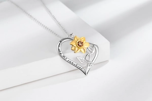 Detail of heart necklace with sunflower pendant and You are my sunshine engraving