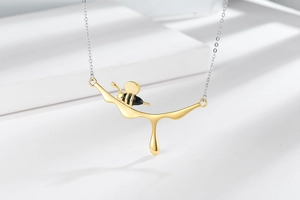 Macro shot of creative golden bee pendant with black and yellow drip art details
