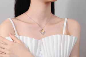 Detail of heart necklace with sunflower charm and You are my sunshine engraving
