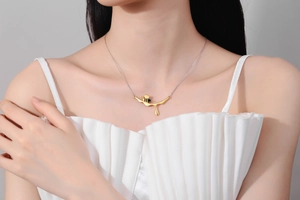 Close-up of golden bee pendant and silver chain necklace worn on a model's neck