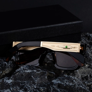 Detailed close-up of golden metal temples with embossed geometric patterns on sunglasses