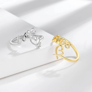 Bague ouverte moderne avec lettrage love et motif coeur sur présentoir géométrique
