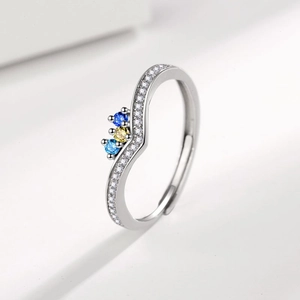 Macro view of adjustable silver wave ring with colorful gemstones and white zircon pave
