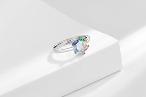 Detailed close-up of adjustable silver ring with colorful geometric zircons on white steps