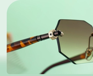 Macro detail of rimless polygonal sunglasses showing gradient lenses and gold hex nut hinges