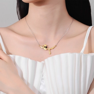 Chic gold honeybee pendant necklace featuring liquid drop design worn by a model