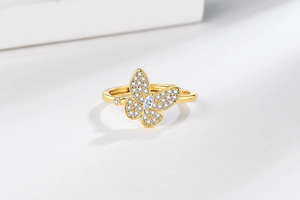 Macro shot of gold butterfly ring with cubic zirconia inlay and adjustable band
