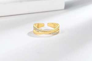Détail macro d'une bague croisée dorée avec sertissage de zircons micro-pavés