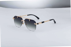 Detail of rimless aviator sunglasses with gray gradient lenses and gold metal temples