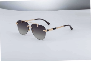 Detail of rimless aviator sunglasses showing gold metal bridge and knurled temple design