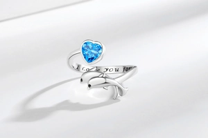 Detailed view of silver whale ring with blue heart stone and inner band engraving