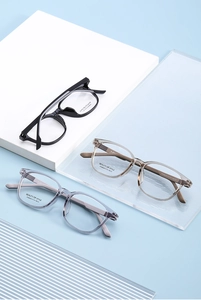 Close-up of stylish square optical frames in black, tea, and grey on elegant props
