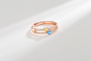 Close-up of double-layer rose gold ring with yellow and blue heart stones and pavé diamonds
