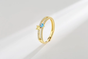 Detailed macro view of double-row gold ring with blue and yellow heart-shaped zircons