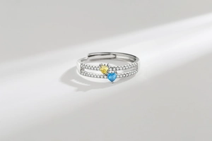 Macro detail of silver double-layered ring with yellow and blue heart-shaped zircons