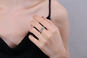 Detail of double-layer silver ring with square yellow and blue gems and pave-set zircons