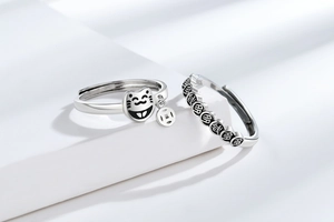 Close-up of silver lucky cat ring with coin charm and FU character band details
