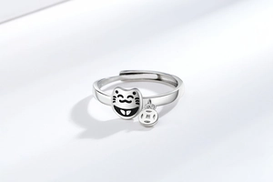 Detail of silver lucky cat ring featuring a hanging coin charm and adjustable open band
