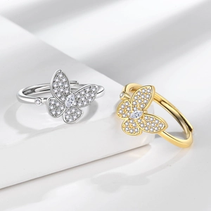 Elegant gold and silver butterfly rings with sparkling cubic zirconia on white podium