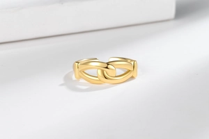 Detail of minimalist gold double-layer knotted chain ring with polished metal finish
