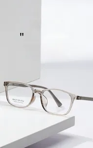 Detail view of transparent brown square optical frames with metal hinges and brand logo