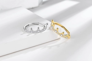 Detail view of crown-shaped rings in silver and gold with pavé set cubic zirconia