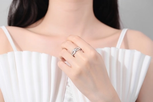 Detail of silver double knot ring with polished finish on model's hand with minimal style