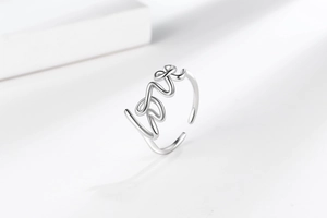Detailed close-up of polished silver Love script letter adjustable open ring