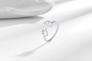 Macro detail of silver adjustable ring with baby hand, foot motif and zirconia accents