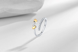 Detail of a two-tone open ring with gold heart accents and pave set cubic zirconia