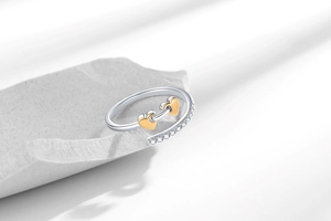 Detailed macro view of an open heart ring with gold accents and cubic zirconia pavé