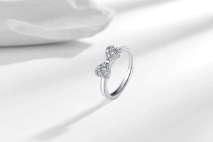 Close-up of silver bow ring featuring micro-pave cubic zirconia and adjustable opening