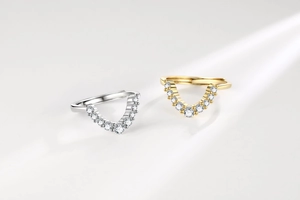 Detailed view of silver and gold U-shaped wishbone rings with micro-paved cubic zirconia