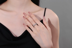 Macro view of bow ring with micro-pave zircons on a model's finger in black dress